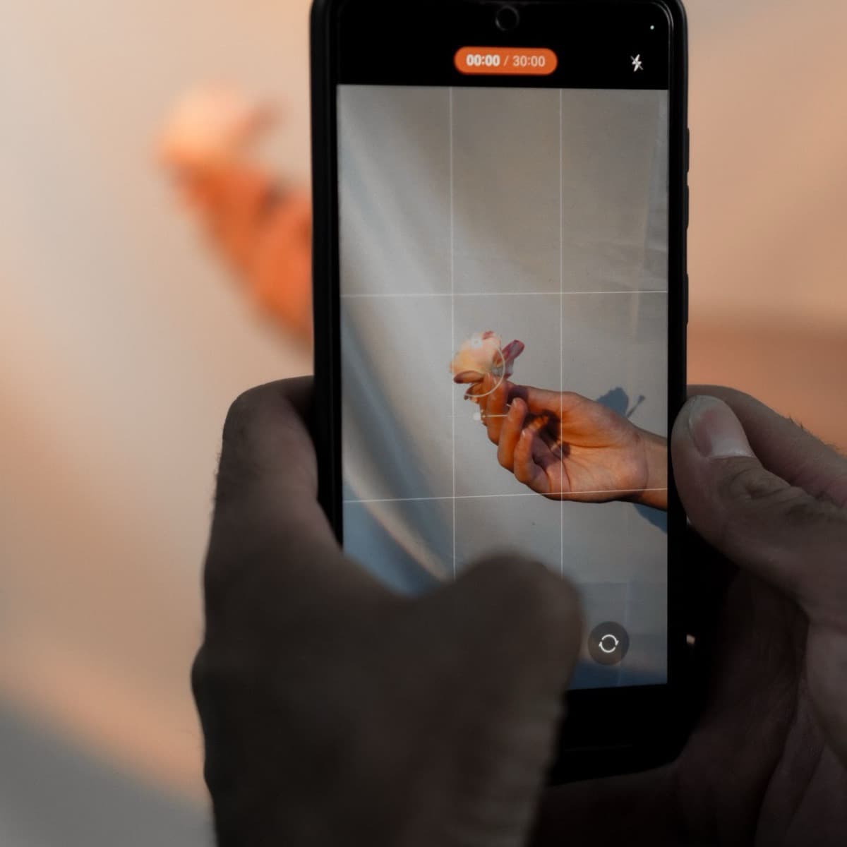 Hands hold a smartphone vertically to film