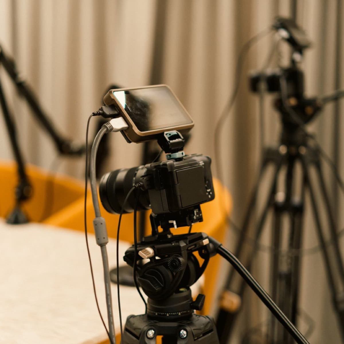 Un studio de podcast avec caméras et micros sur bras articulés